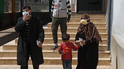 Displaced Syrians wear protective masks as they leave a lecture provided by staff from Turkey's Humanitarian Relief Foundation to raise awareness about the coronavirus pandemic at a refugee camp in Kafr Lusin, Syria, on March 23, 2020. AFP